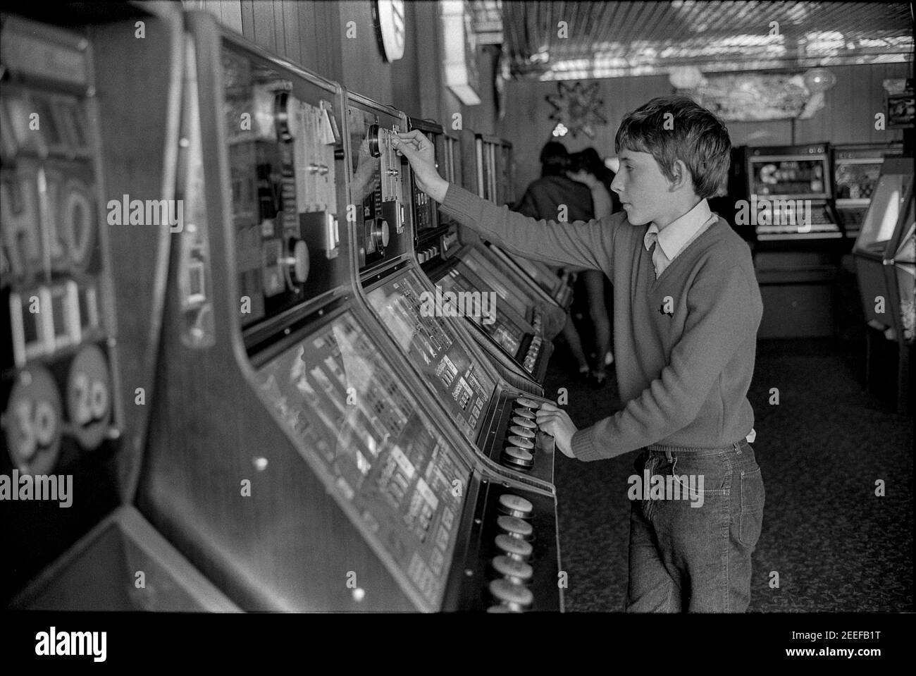 Young Boy Playing Fruit Machine Stock Photo