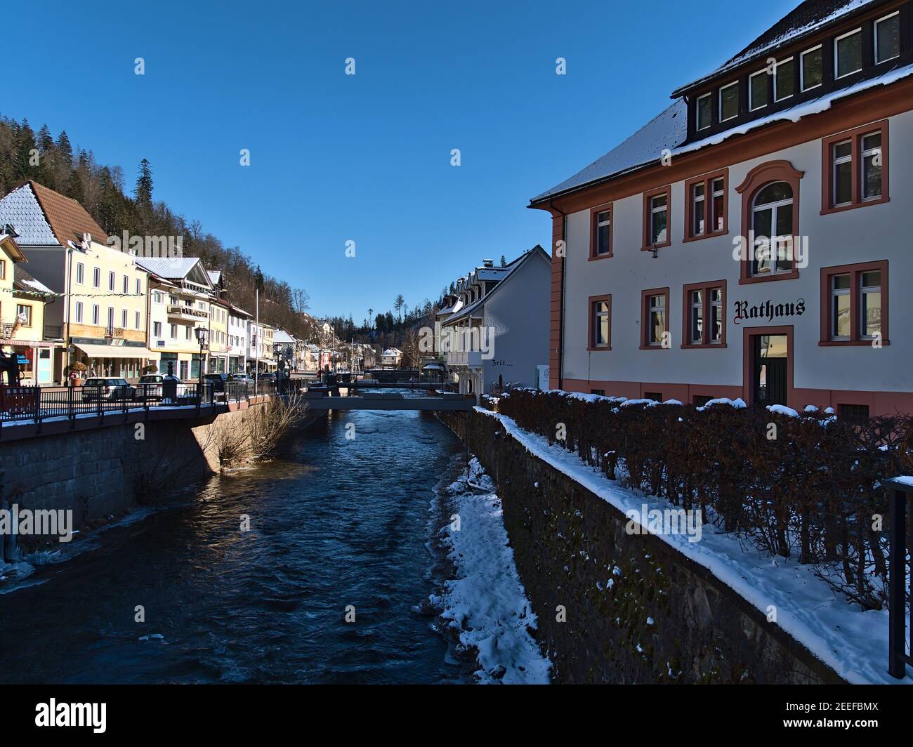 View of historic town center with river Alb and town hall ('Rathaus', right) in winter season with snow and ice on sunny day. Stock Photo