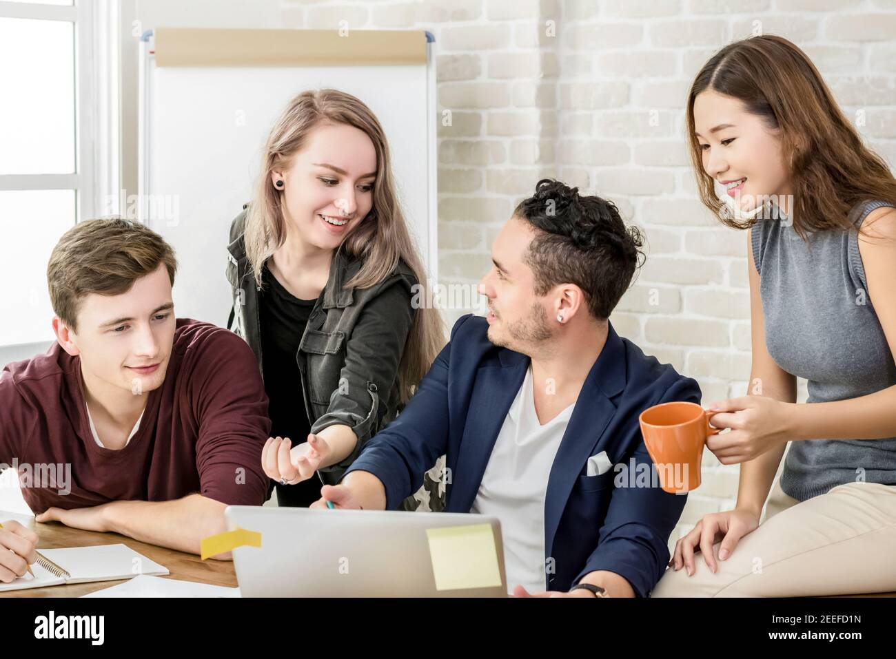 Multiethnic college students discussing group work together - education concept Stock Photo