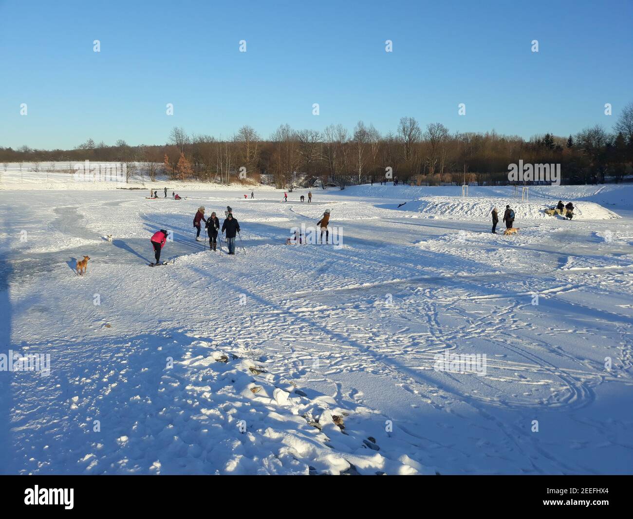 Ricany, Czech Republic. 15th Feb, 2021. People enjoy the sunny wintry weather and winter sports on the frozen pond Rozpakov in Ricany, Czech Republic, February 15, 2021. Credit: Jan Kholl/CTK Photo/Alamy Live News Stock Photo