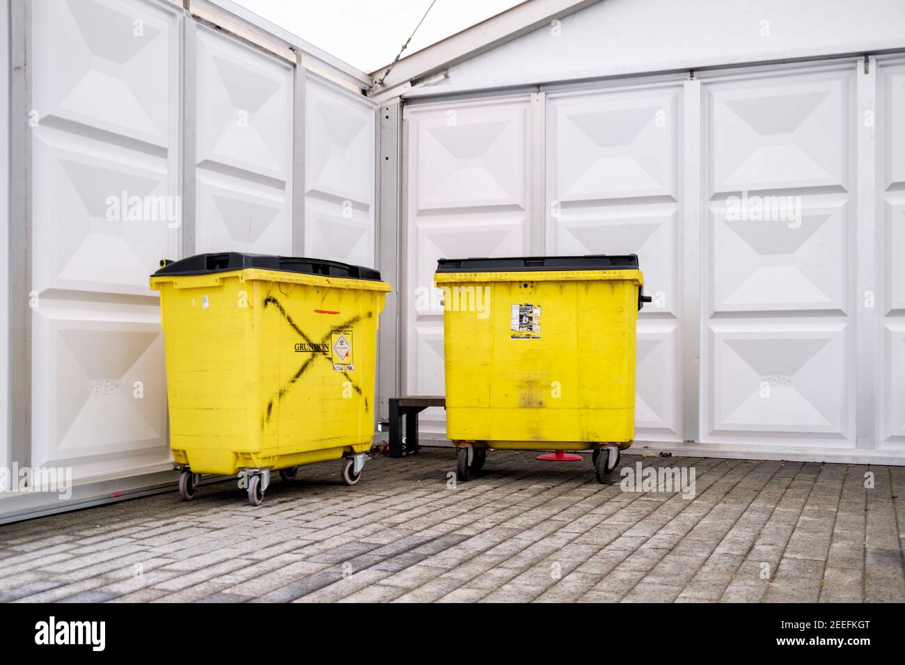 Two yellow wheelie bins used for clinical waste outside a covid19 testing facility at Middlesex University, Hendon, London. Stock Photo