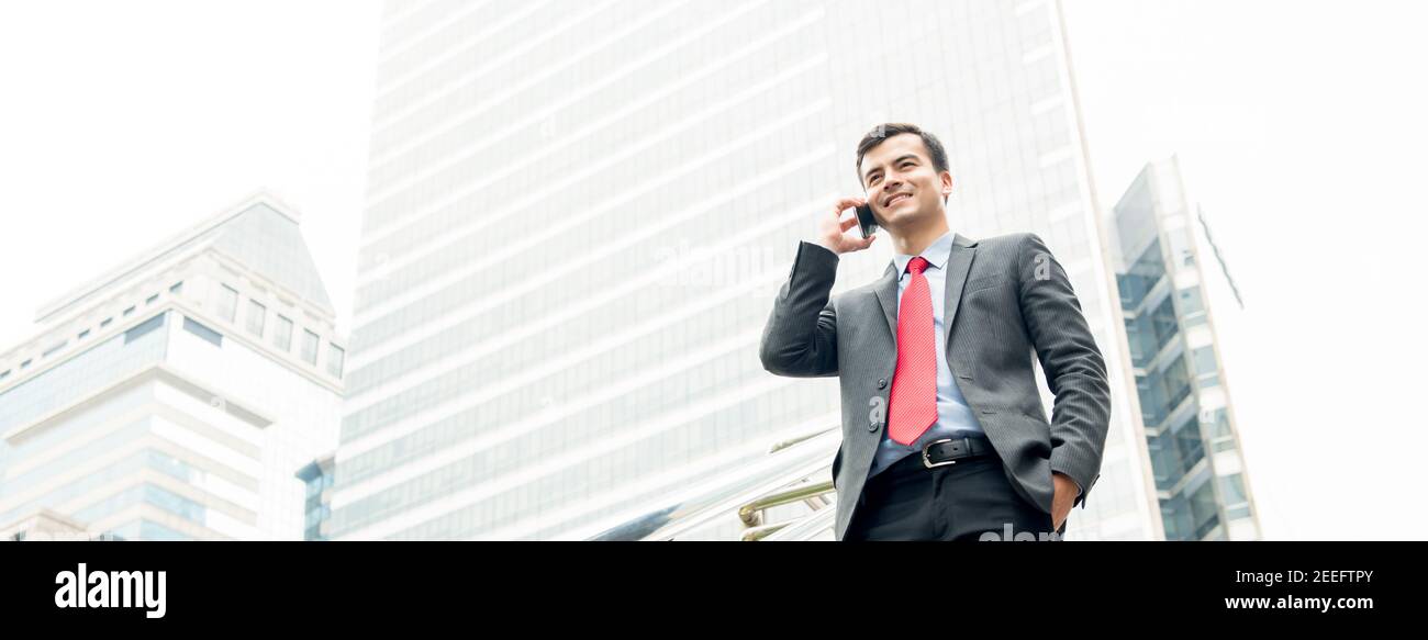 Businessman calling on mobile phone in the city - panoramic web banner Stock Photo