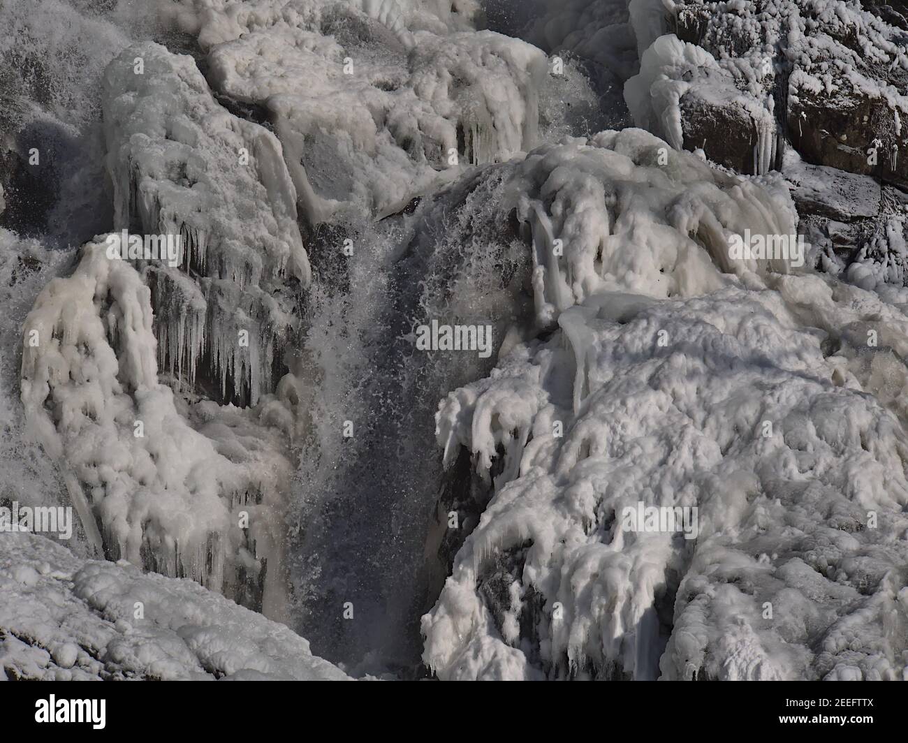 Closeup view of popular water cascades Todtnauer Wasserfälle with spray in winter season and bizarre looking ice formations with many icicles. Stock Photo