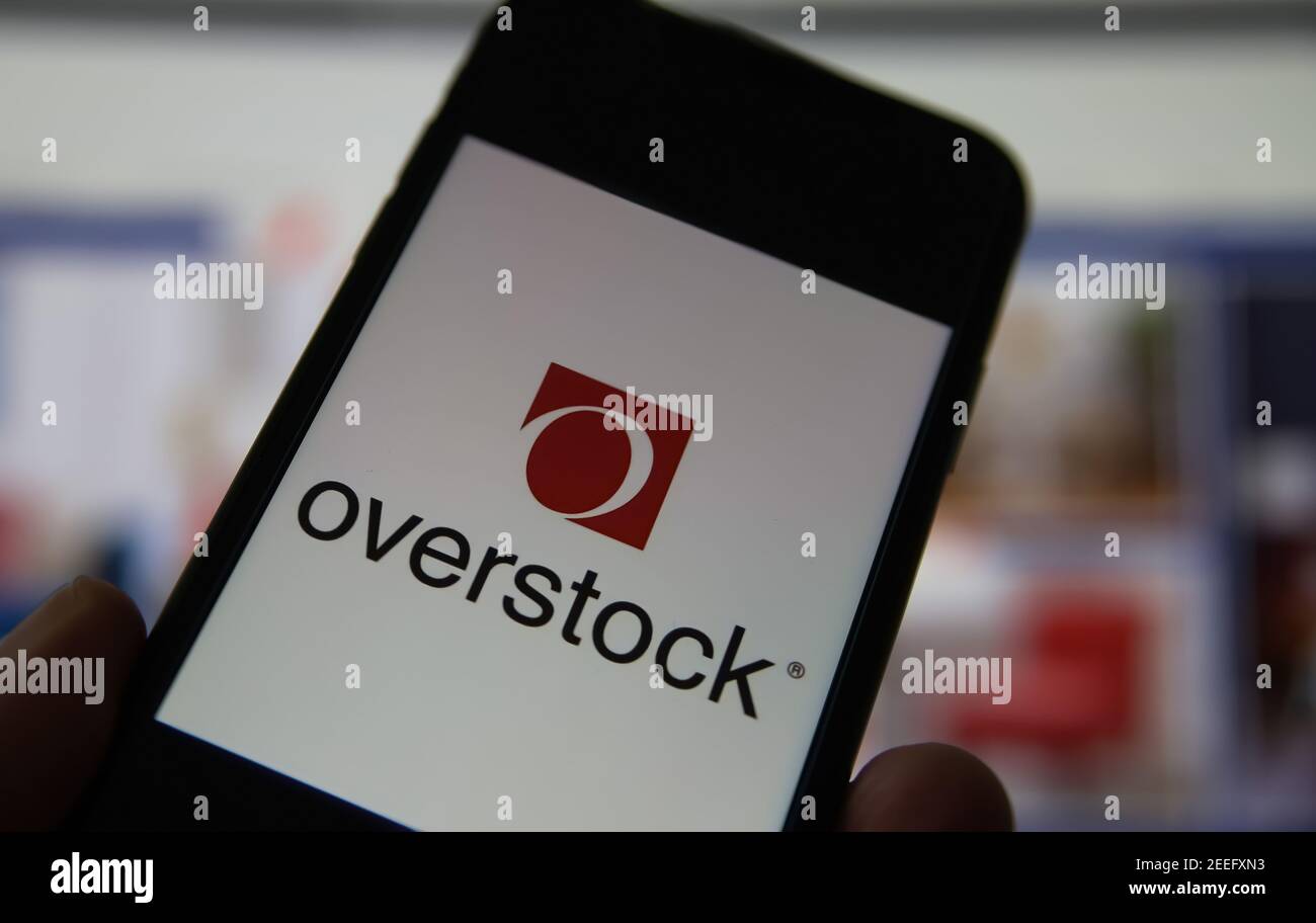 Viersen, Germany - February 9. 2021: Closeup of smartphone screen with logo lettering of overstock furniture company, blurred website background Stock Photo