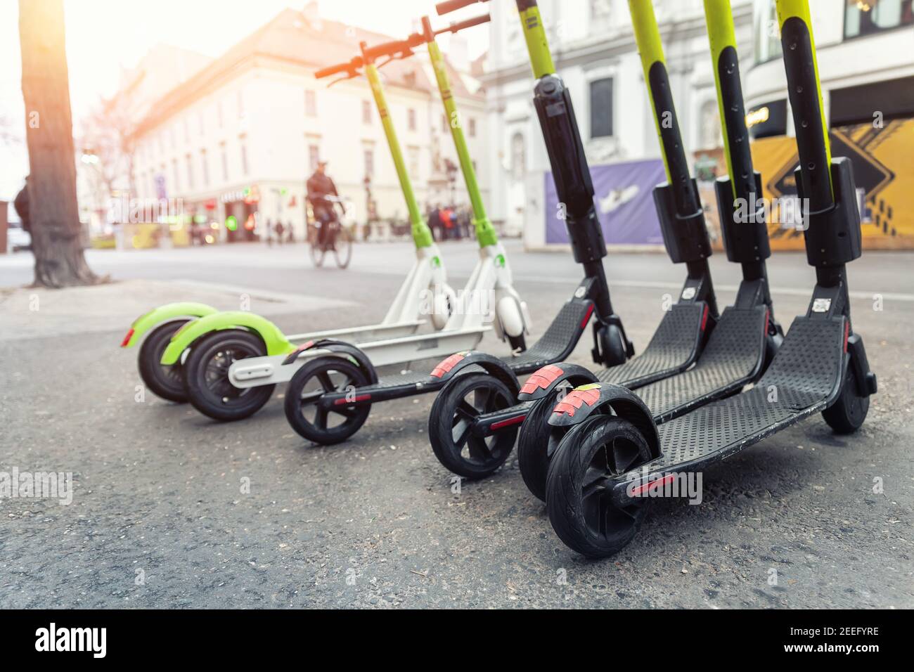 Many modern electric kick scooters sharing parked on city street. Self