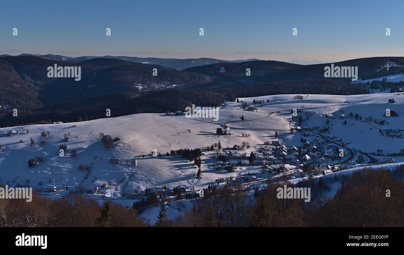 Beautiful aerial view of small rural village Hofsgrund, part of Oberried, Germany in the Black Forest hills in winter with snow-covered landscape. Stock Photo