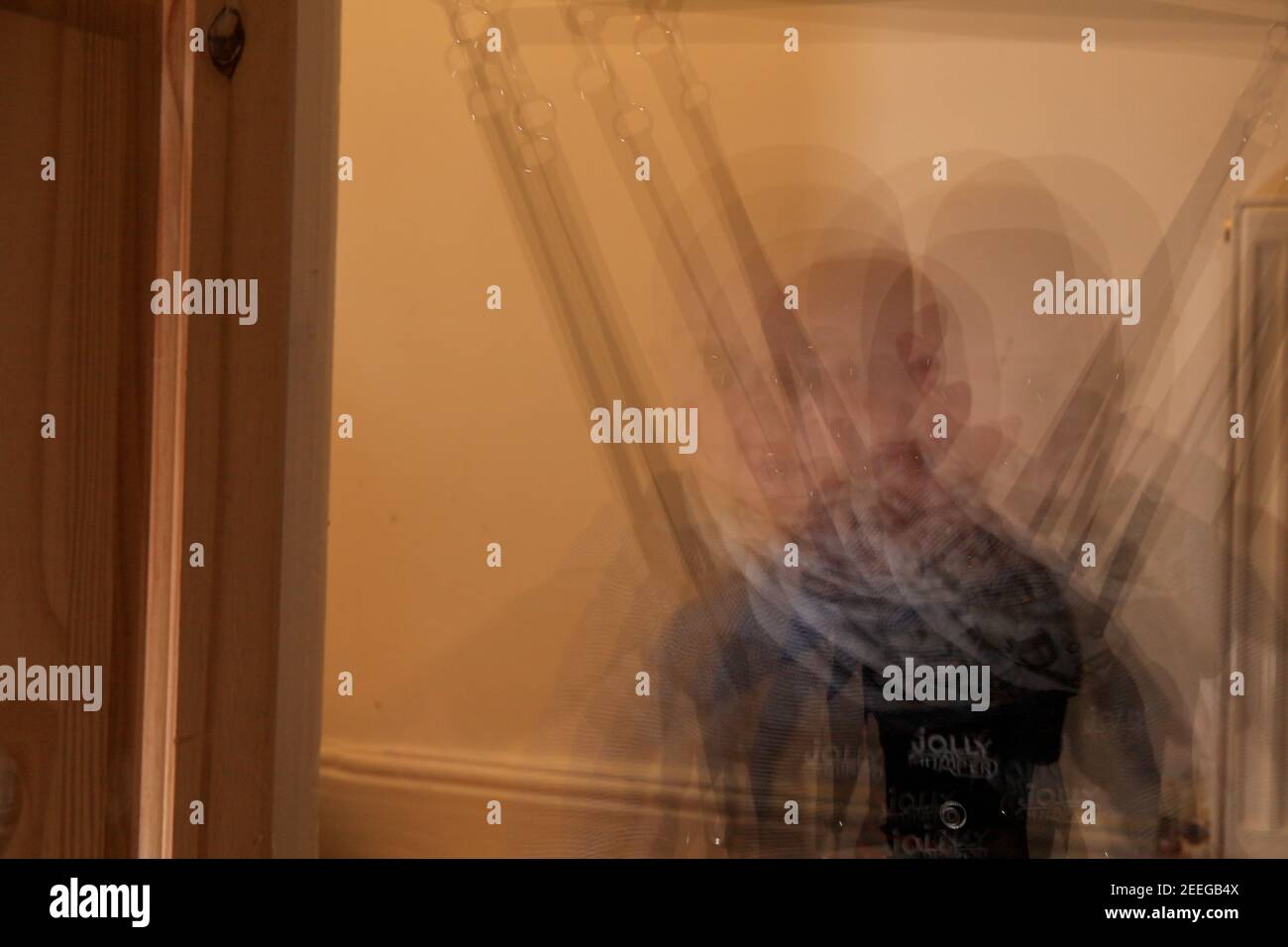 Multi exposure on a caucasian baby boy on the Jumper Baby Exerciser. Middle shot inside of the house. Stock Photo