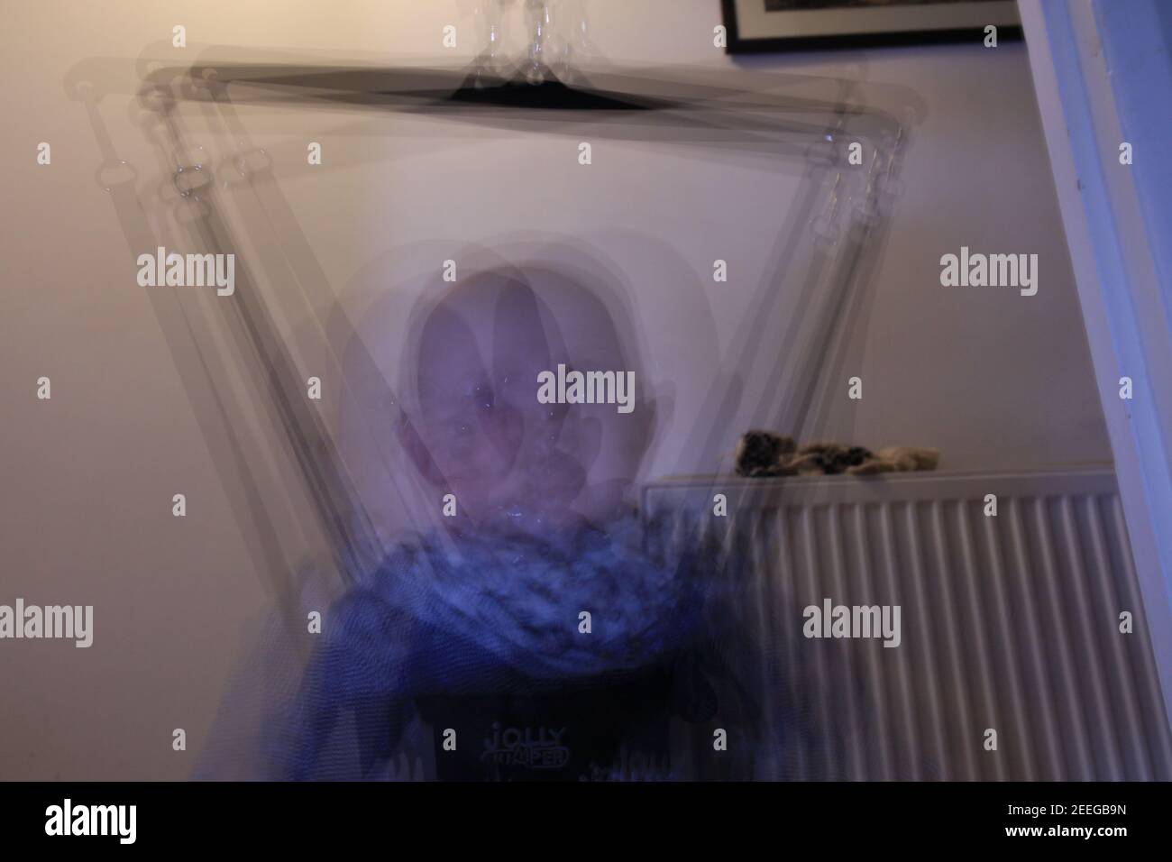 Multi exposure on a caucasian baby boy on the Jumper Baby Exerciser. Middle shot inside of the house. Stock Photo
