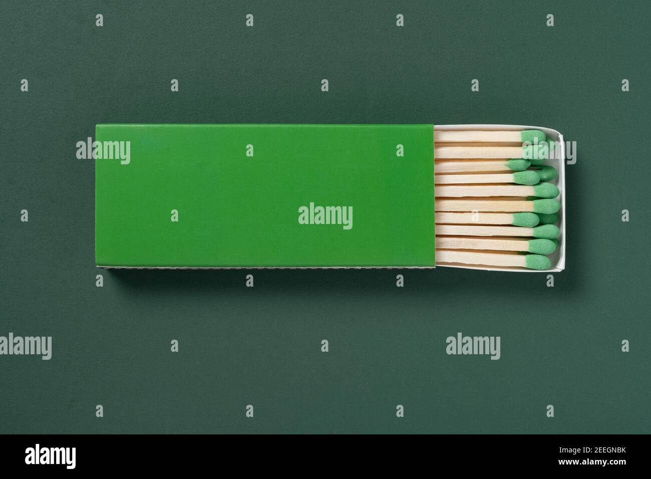 green matchbox and green match sticks on a green background Stock Photo