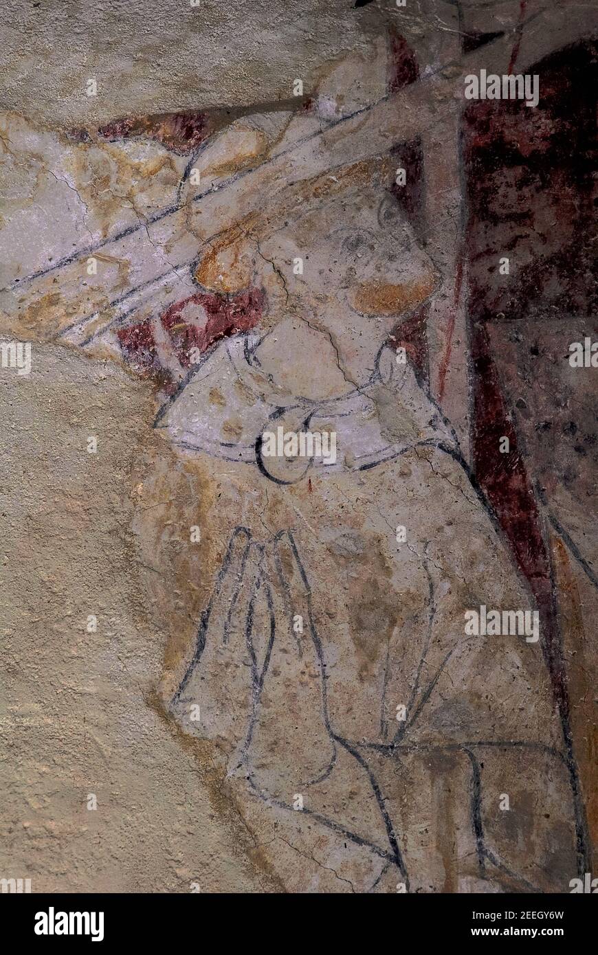 A broadsword slices into the skull of ‘turbulent priest’ Archbishop Thomas Becket as he kneels in prayer, about to be murdered, in Canterbury Cathedral on 29 December 1170.  Detail of late 1200s medieval wall painting in the Parish Church of Saint Augustine at Brookland, Kent, England.  Becket was killed by four knights, supporters of King Henry II, after arguing with the king over church rights and privileges.  Becket was canonised in 1173 and is venerated as a saint and Christian martyr by both Roman Catholics and Anglicans. Stock Photo