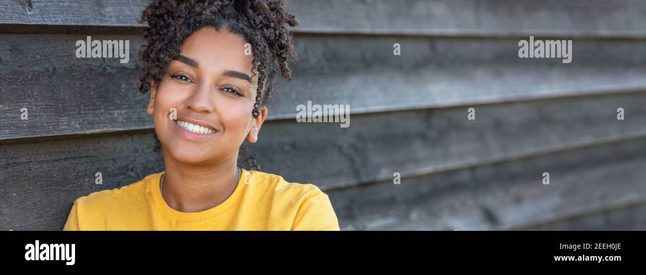 Panorama girl teenager teen female young African American mixed race biracial woman outside smiling with perfect teeth panoramic header web banner Stock Photo