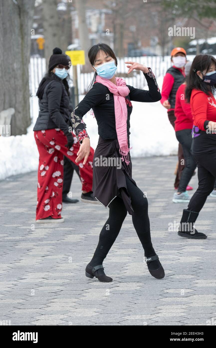 A slender graceful Chinese American woman teaches a dance exercise class in a park in Queens, New York City. Stock Photo