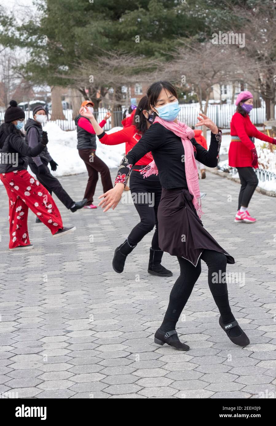 A slender graceful Chinese American woman teaches a dance exercise class in a park in Queens, New York City. Stock Photo