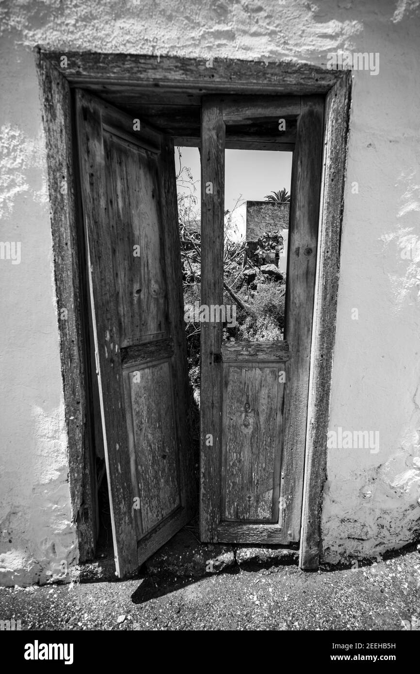 Vertical grayscale shot of an old abandoned door Stock Photo - Alamy