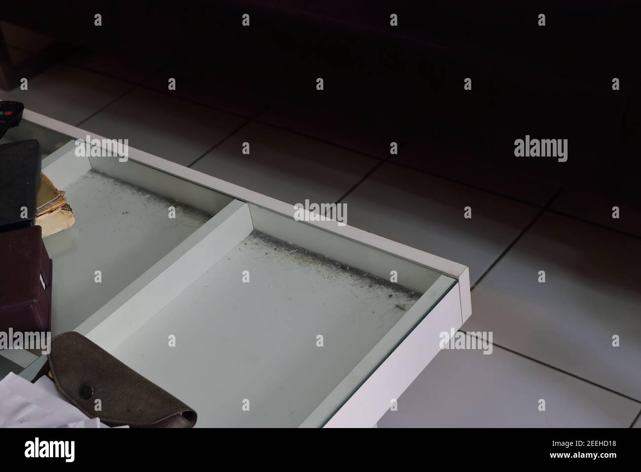 Selective focus of dust under glass table top of messy coffee table in