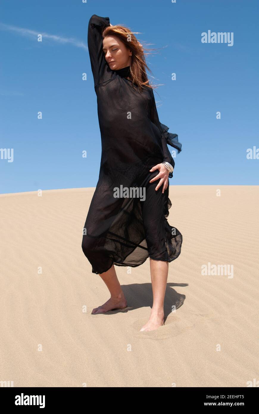 young muslim woman in a black robe in the desert Stock Photo - Alamy