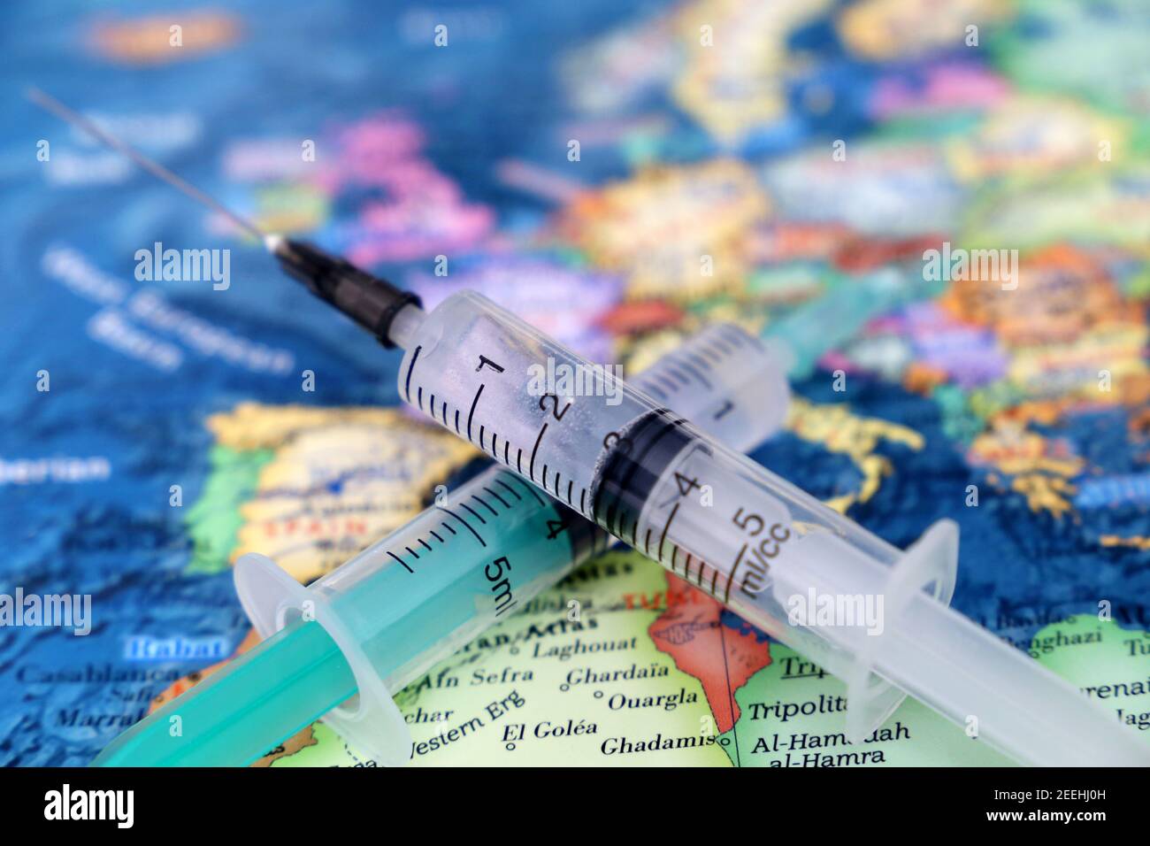 Syringes on the map of Europe and North Africa, selective focus. Concept of vaccination in EU countries during covid-19 pandemic Stock Photo