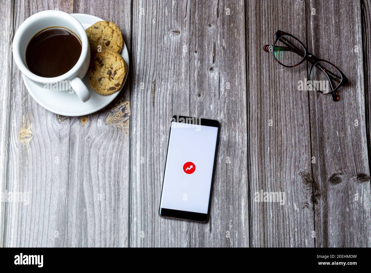 A mobile phone or cell phone laid on a wooden table with the app open ...