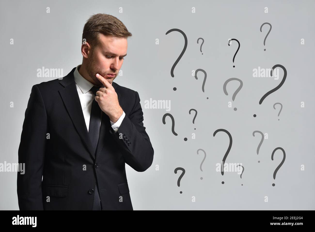 Attractive man in a suit is thinking how to solve the accumulated problems Stock Photo