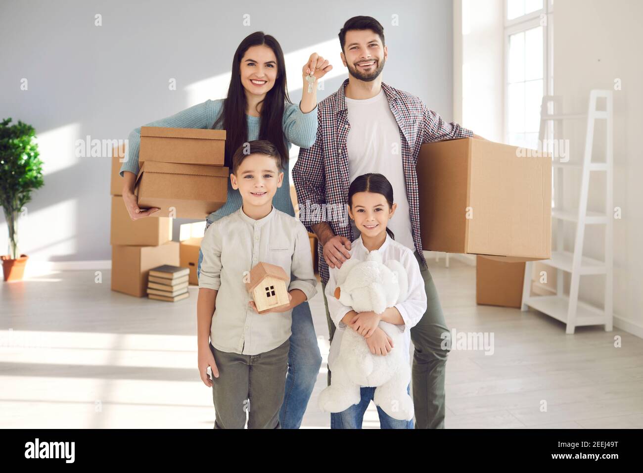 Portrait of happy family with children showing keys to their new home ...