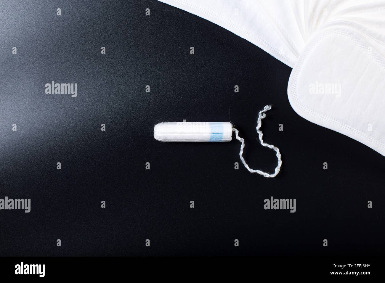 Tampon and thin panty liners on black background with copy space Stock