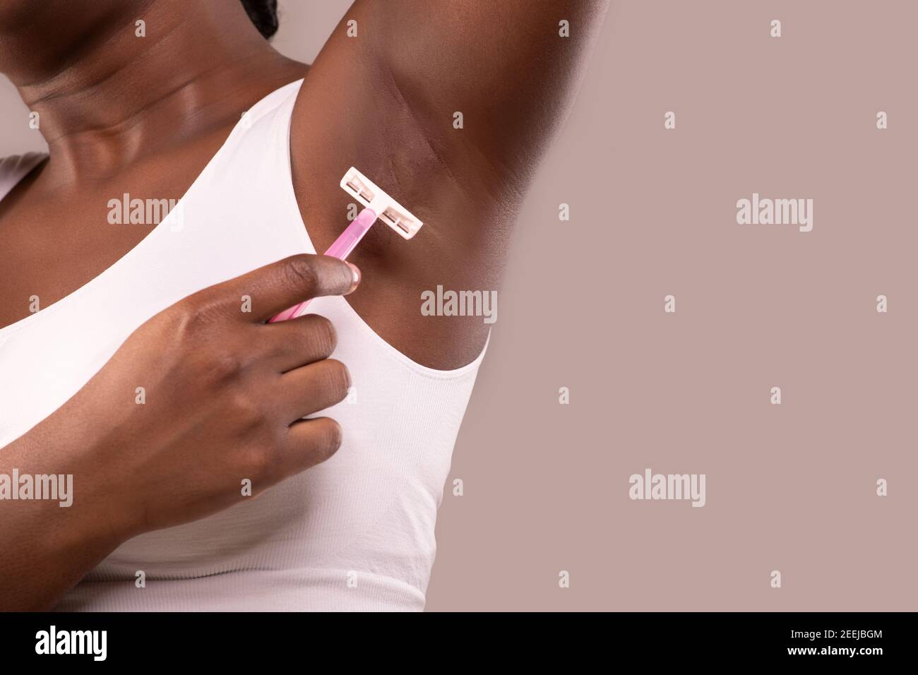 Hair Removal. Unrecognizable Black Woman Shaving Her Armpit With Pink Razor Stock Photo