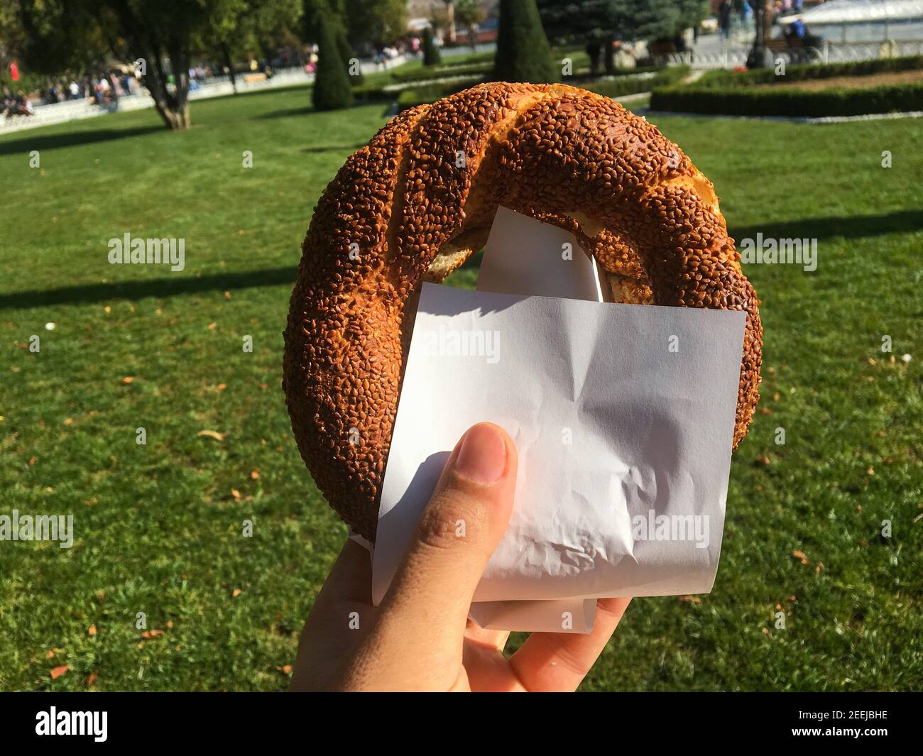Close-up male hand holding Simit a circular Turkish bread Stock Photo