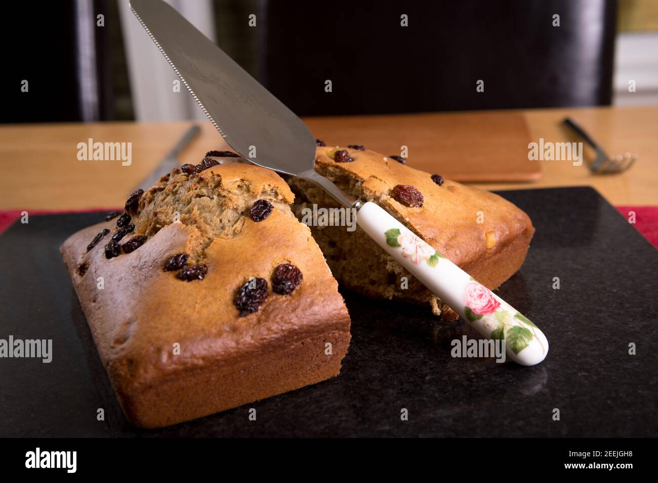 Freshly made banana cake with knife on a marble bread board. Stock Photo