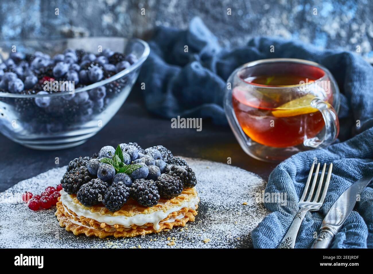 homemade waffles with blueberries and blackberries, powdered sugar on a stone plate with fruit. Shallow depth of field. Stock Photo