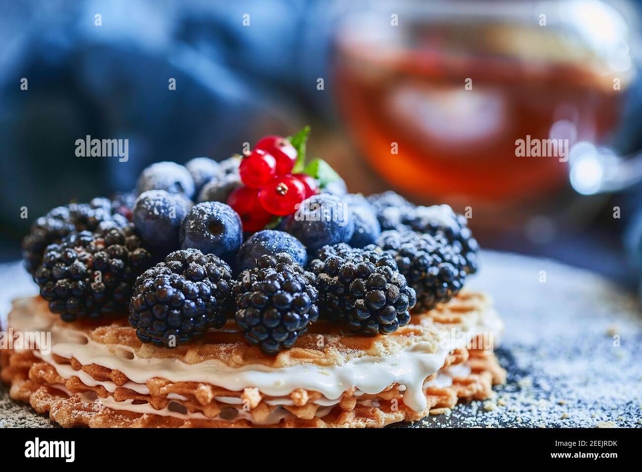 homemade waffles with blueberries and blackberries, powdered sugar on a stone plate with fruit. Shallow depth of field. Stock Photo