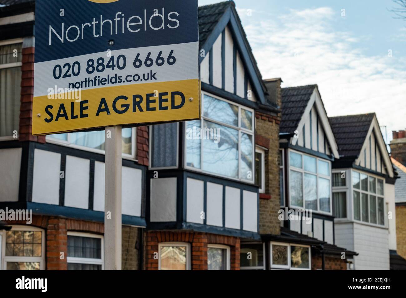 London-  Northfields estate agent 'Sale Agreed' sign on row of terraced houses in Ealing, west London Stock Photo