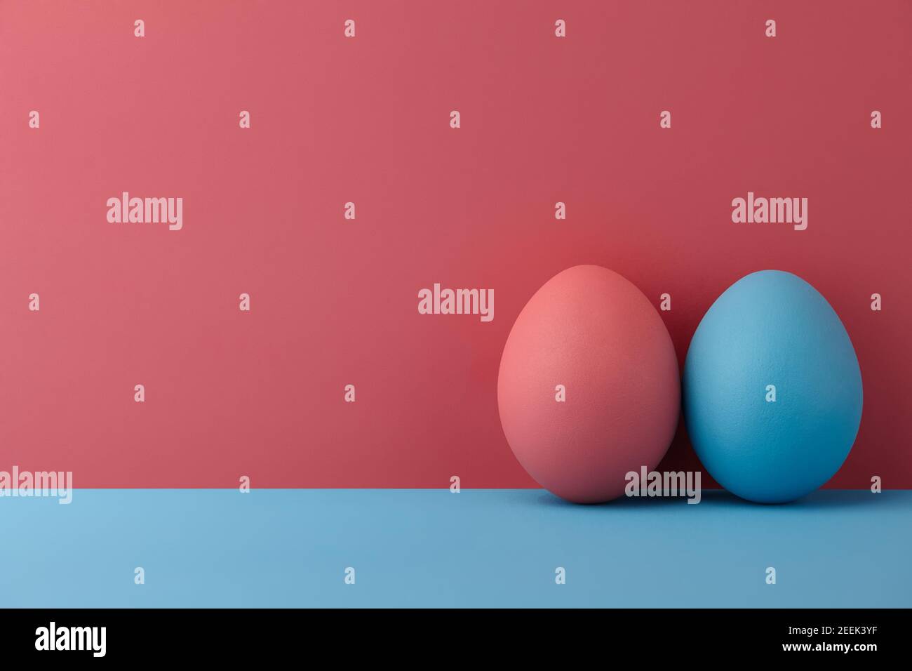 Painted Easter eggs on pink and blue background, copy space Stock Photo