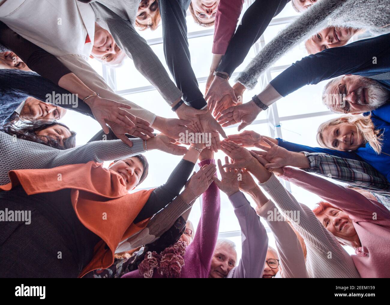 Creative business team stacking hands together in office Stock Photo ...