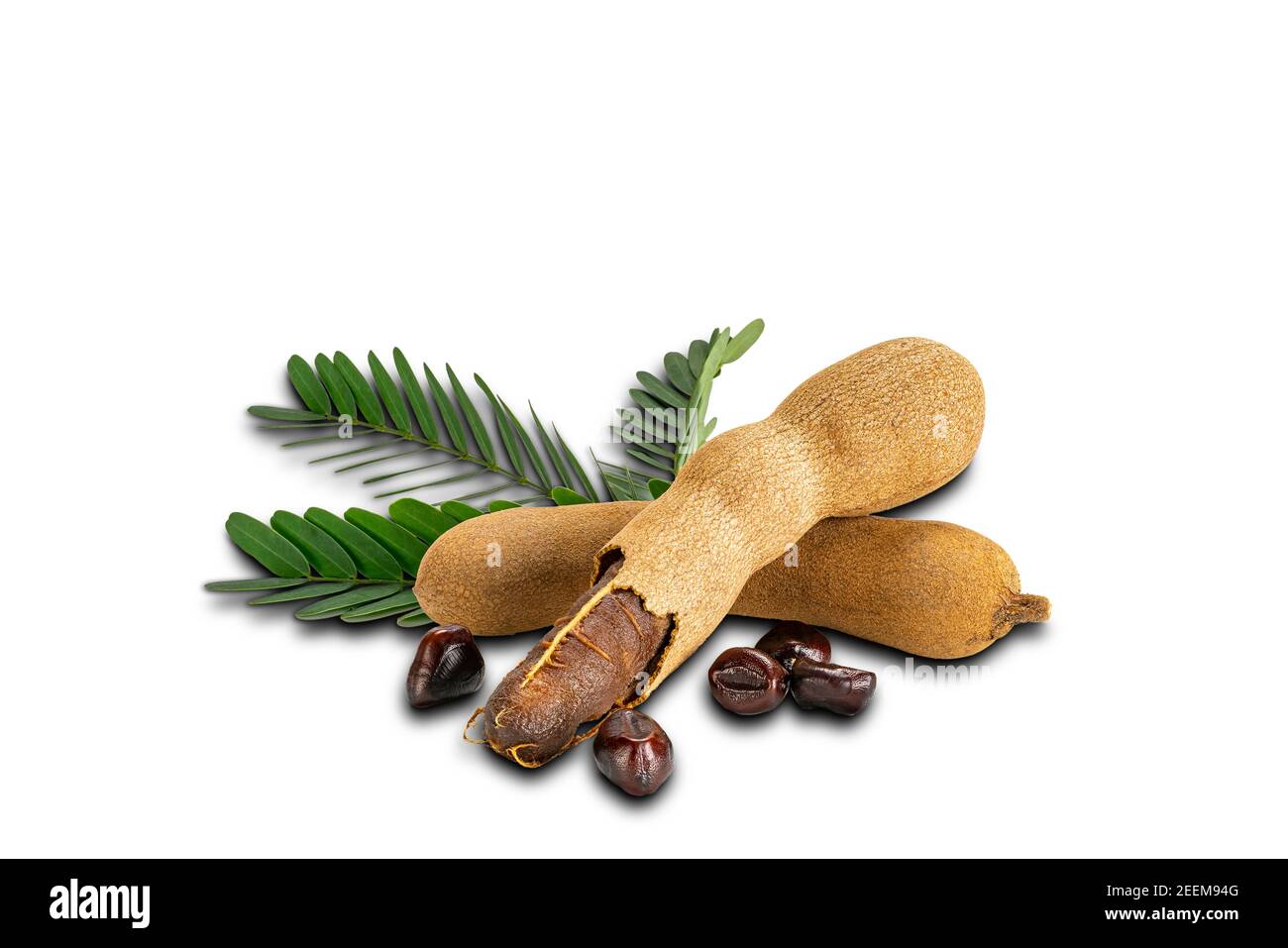 Tamarind with leaves and seeds on white background with clipping path. Ripe tamarind peel shell and hard dark seeds. Stock Photo
