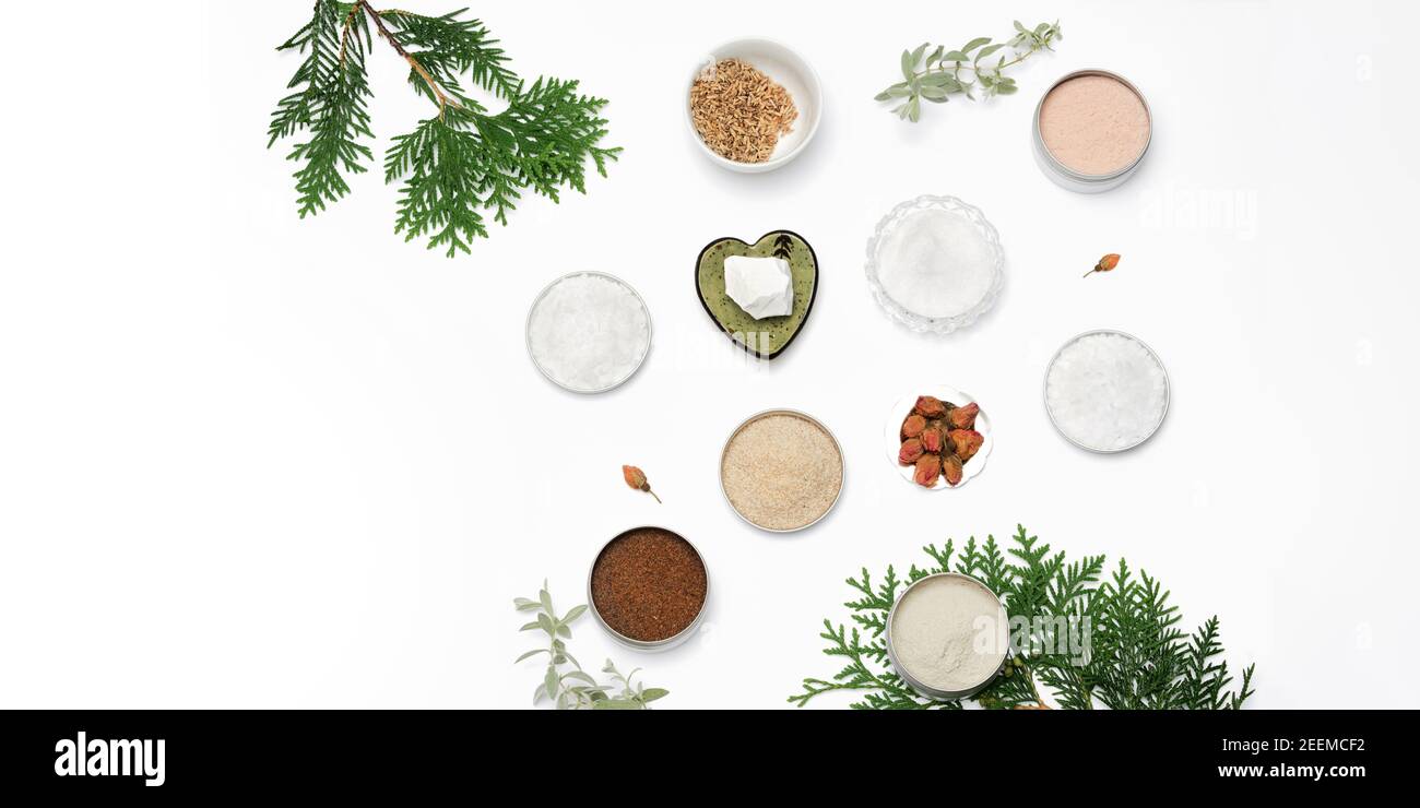Ingredients for the production of cosmetics on a white background. Clays, wax, herbal powders, dried flowers, raspberry ketone, menthol crystals. Natural cosmetics concept. Banner. Stock Photo