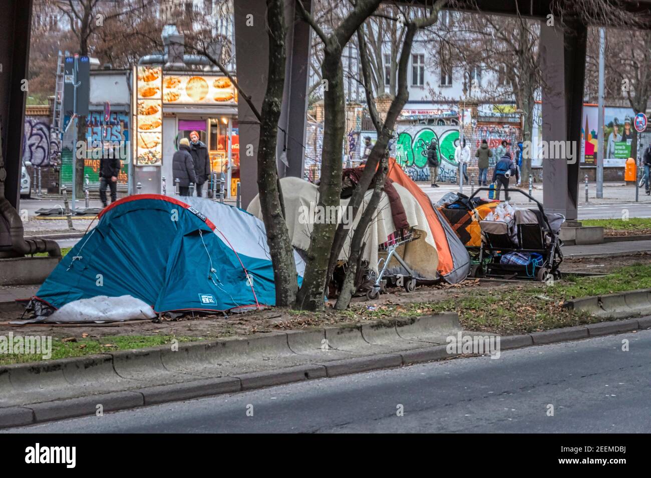 Obdachlose in Zelten unter U-Bahn Trasse der U1 , im Hintergrund Drogendealer am Görlitzer Park, Kreuzberg, Berlin Stock Photo