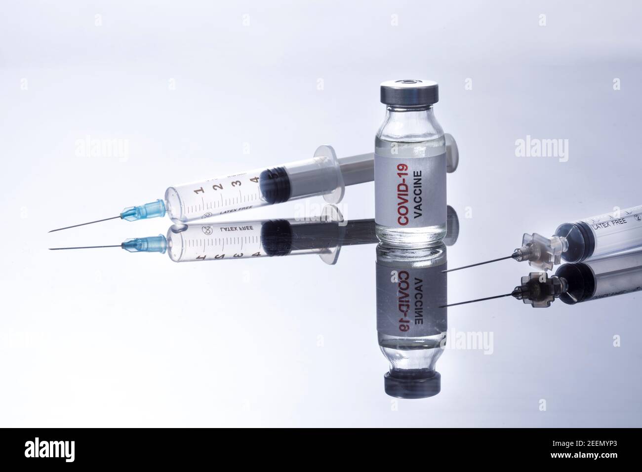 Coronavirus Vaccine Bottle with Syringes, Isolated on White Reflective Background Stock Photo