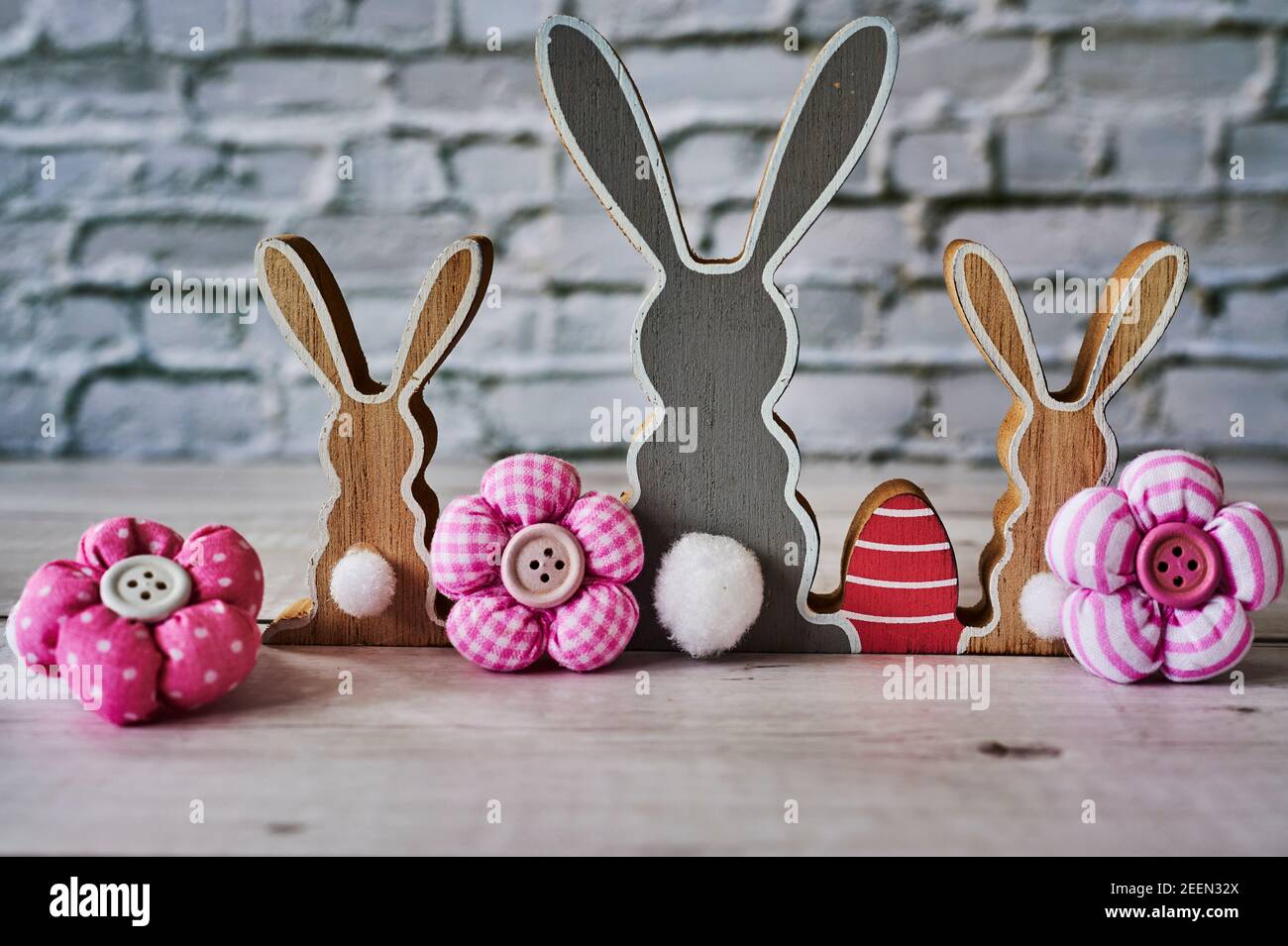 Three wooden Easter bunnies from behind with decoration. Stock Photo
