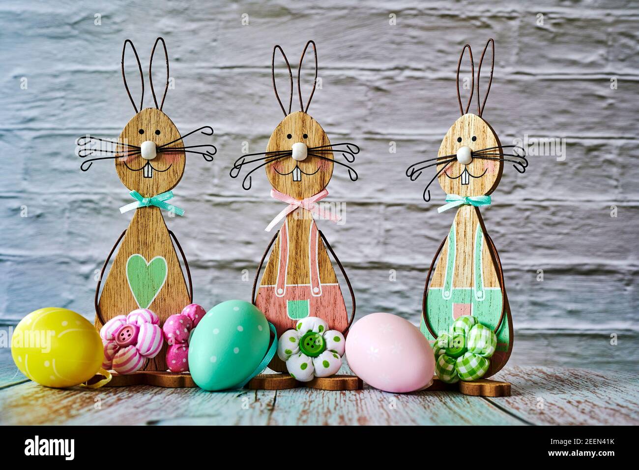 Three wooden Easter bunnies with decoration. Stock Photo