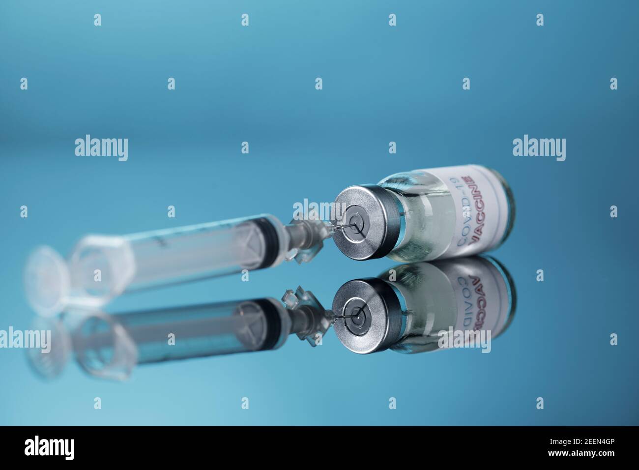 drawing of the anti-covid vaccine with a syringe from a glass fillet, isolated on reflective background Stock Photo