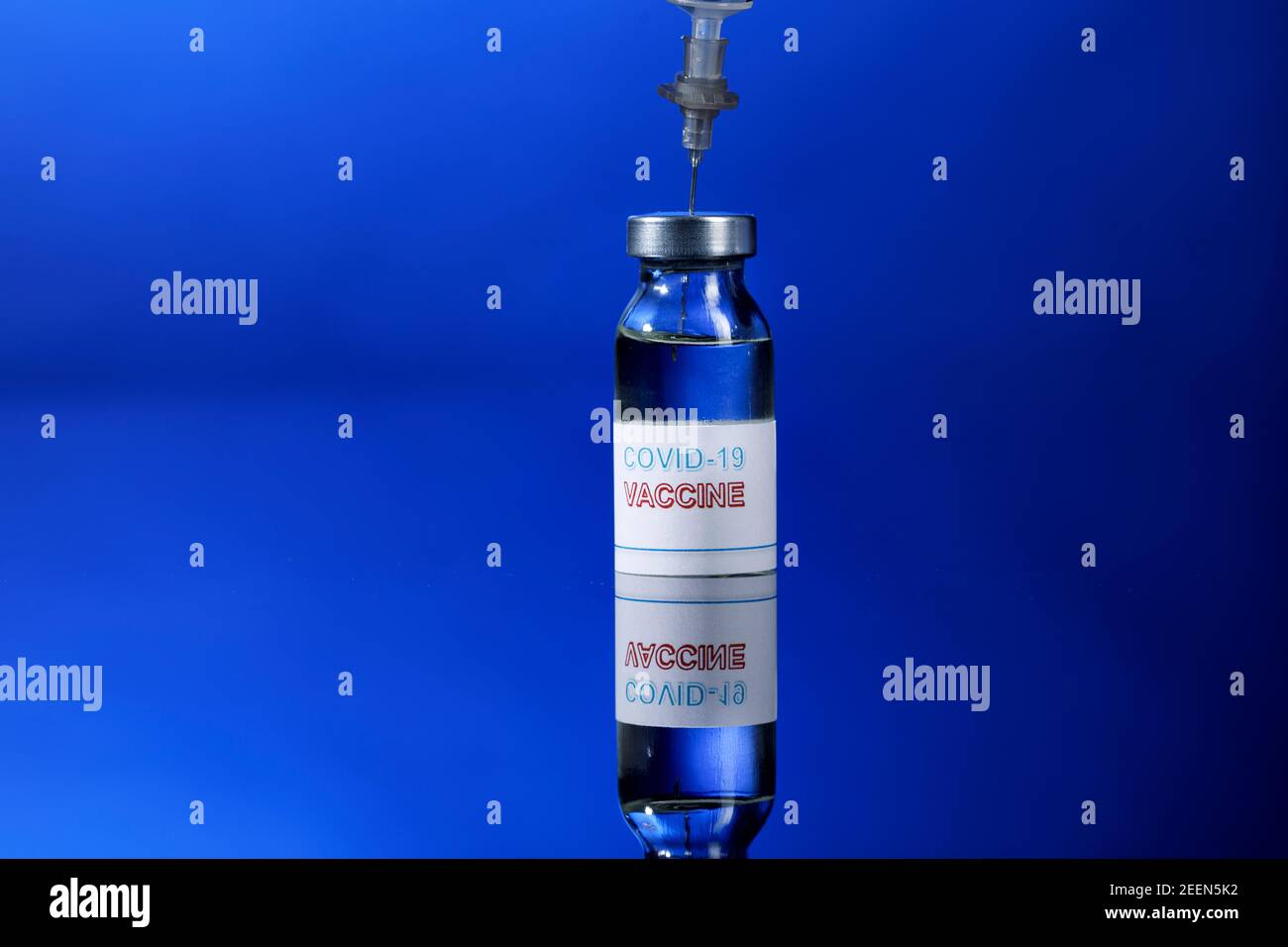 drawing of the anti-covid vaccine with a syringe from a glass fillet, isolated on reflective background Stock Photo