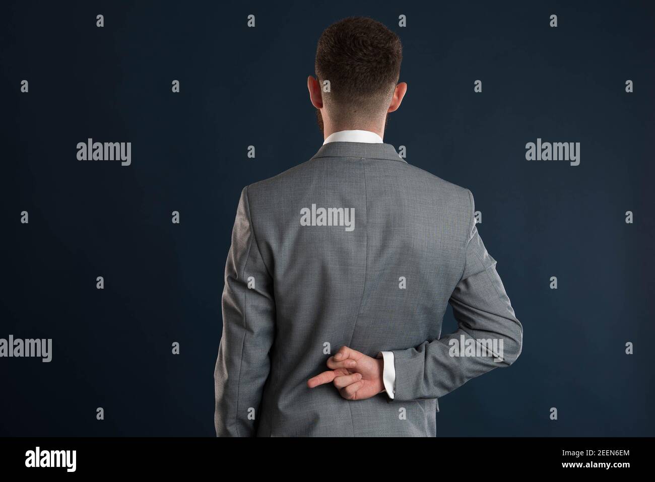 Young businessman showing fuck you with his back turned to the camera Stock Photo