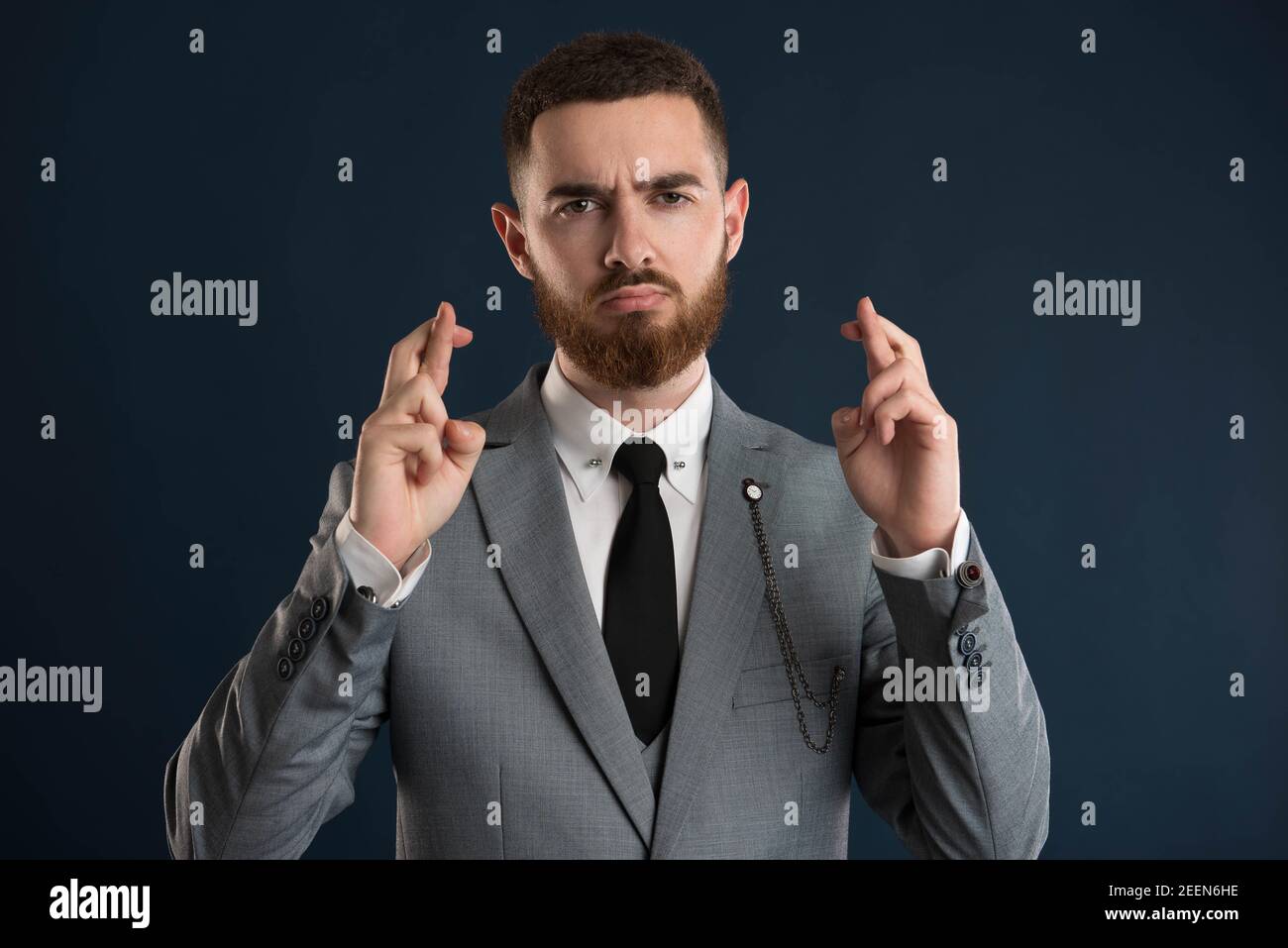 Young handsome businessman showing bad luck sign wearing a black tie Stock Photo