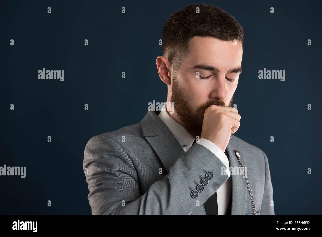 Handsome white collar worker yawning wearing a grey jacket Stock Photo