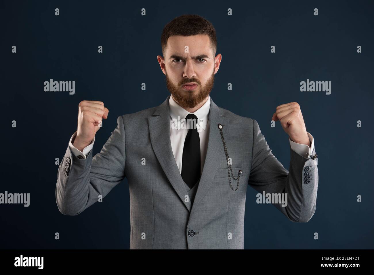 Young businessman feeling like a winner wearing a black stie and a grey suit Stock Photo