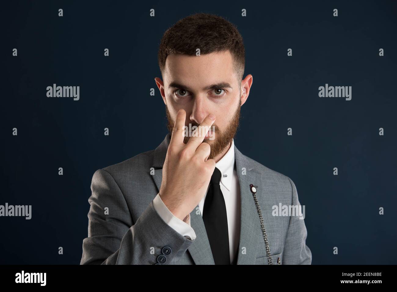 Young entrepreneur saying look intro my eyes wearing a grey suit Stock Photo
