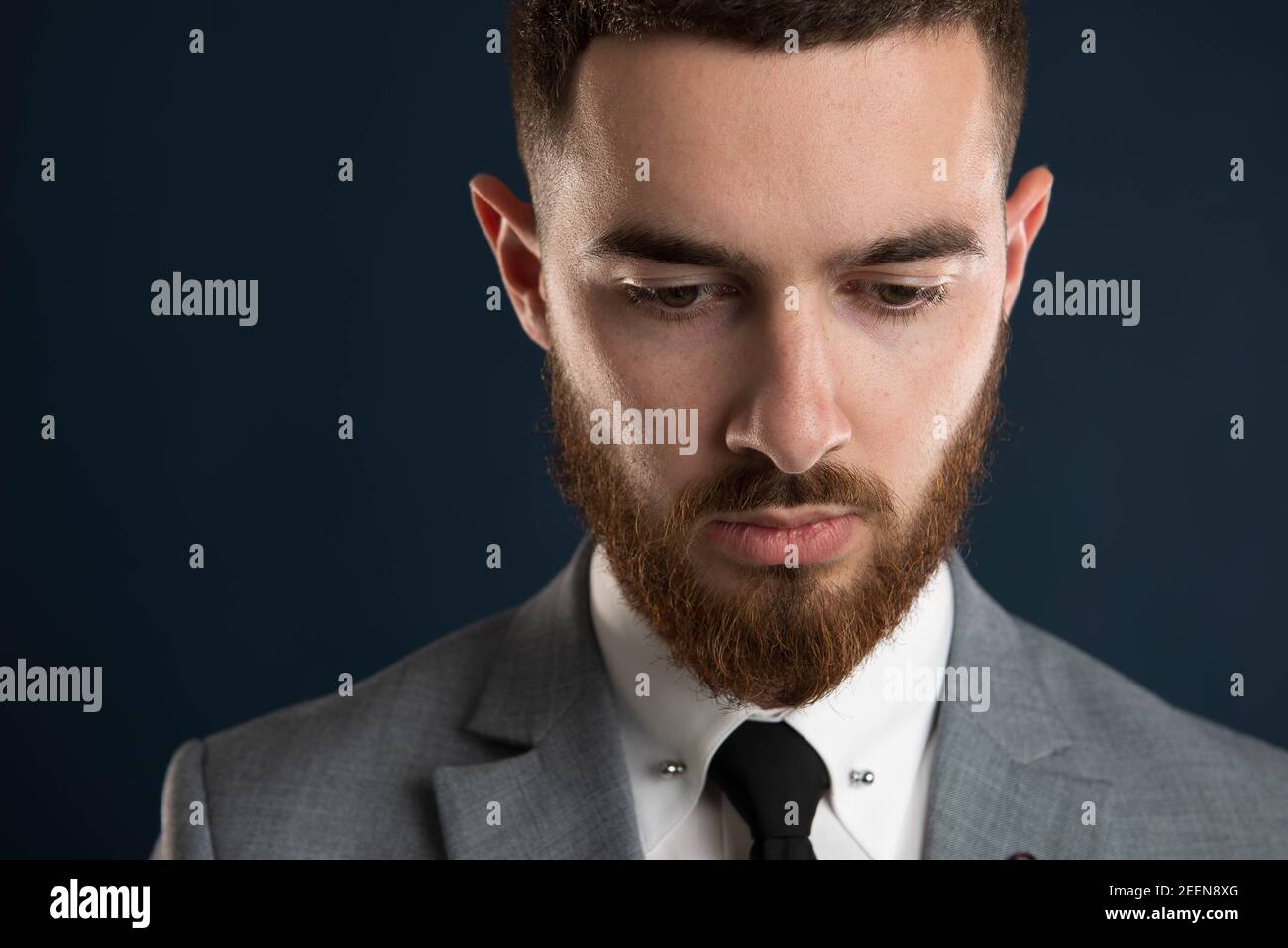 Closeup of the face of a young attractive entrepreneur wearing a grey suit and full beard Stock Photo