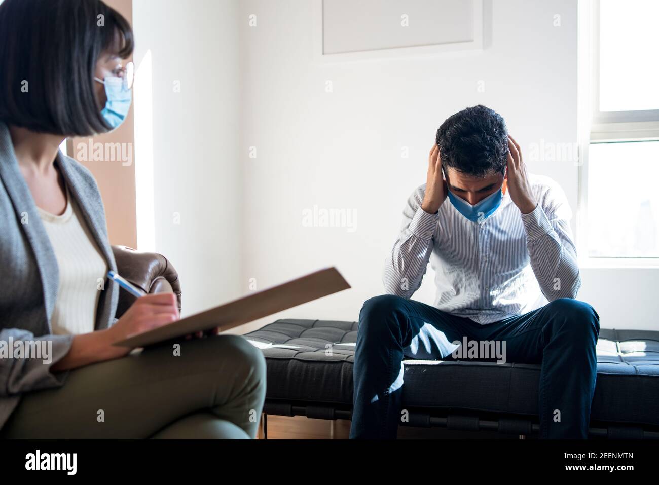 Psychologist talking with patient on therapy session. Stock Photo