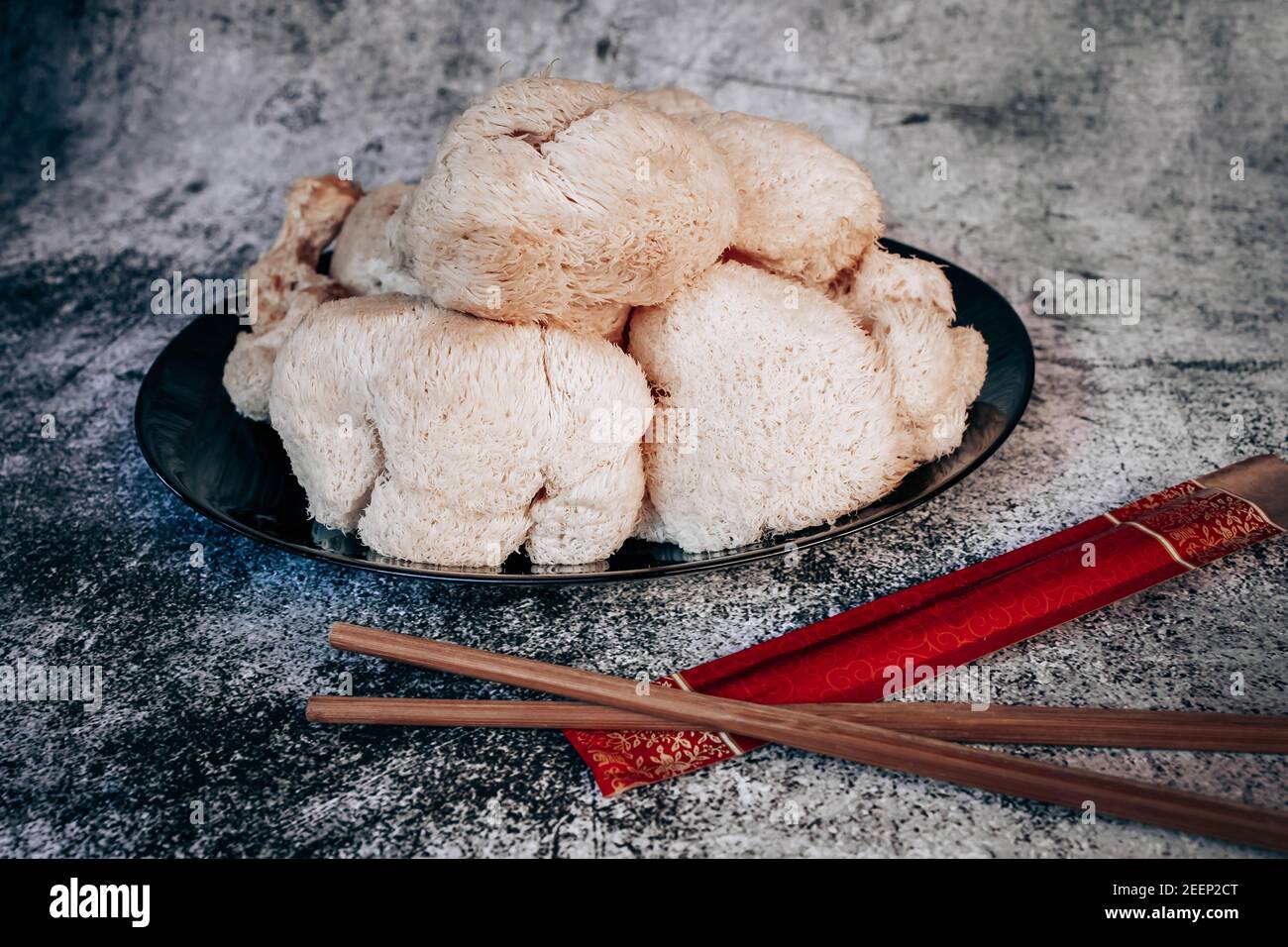 Hericium erinaceus or Lions mane mushrooms on a plate with Chinese sticks. Medical mushroom concept Stock Photo