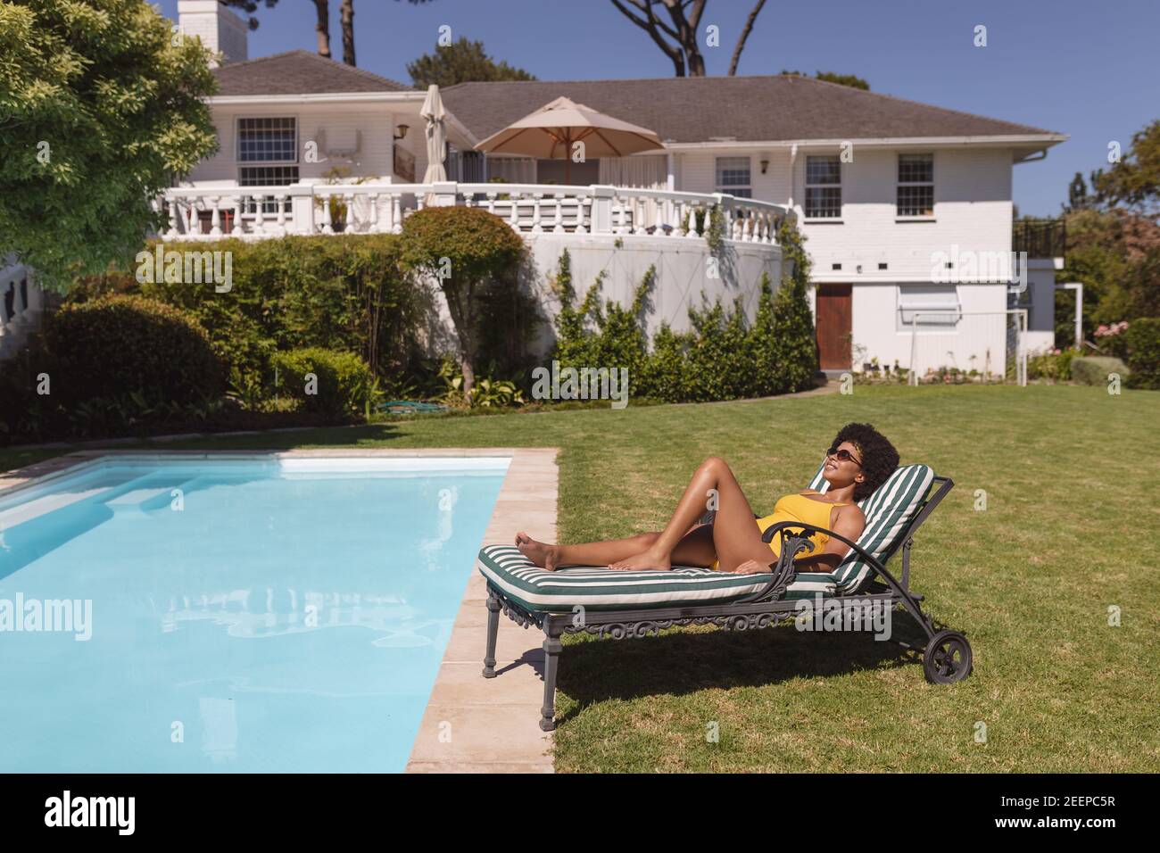 Diverse Group Of Friends Sunbathing Together By Pool On A Sunny Day 